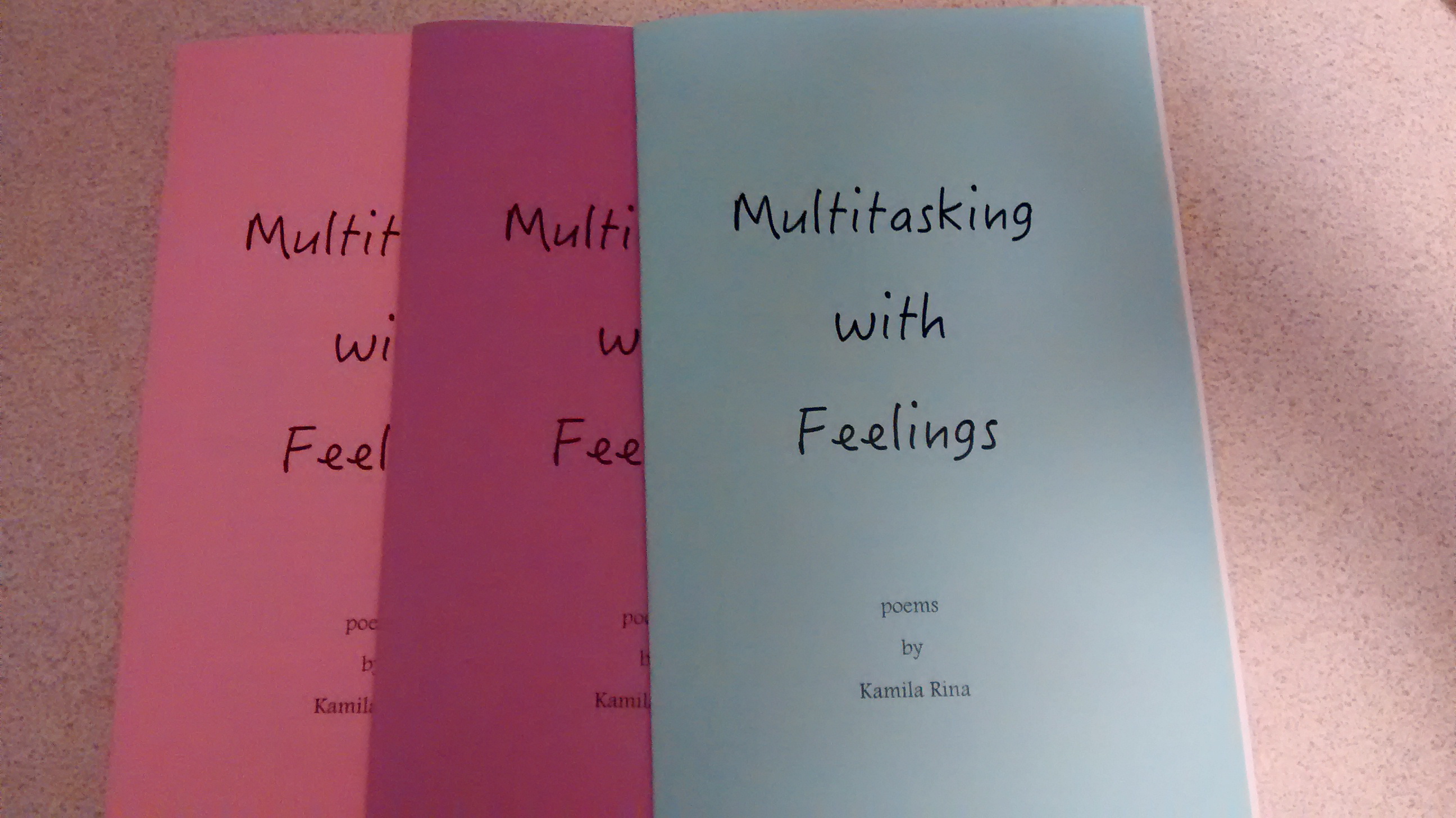 3 poetry chapbooks in pink, purple, and blue. All are titled "Multitasking with Feelings".