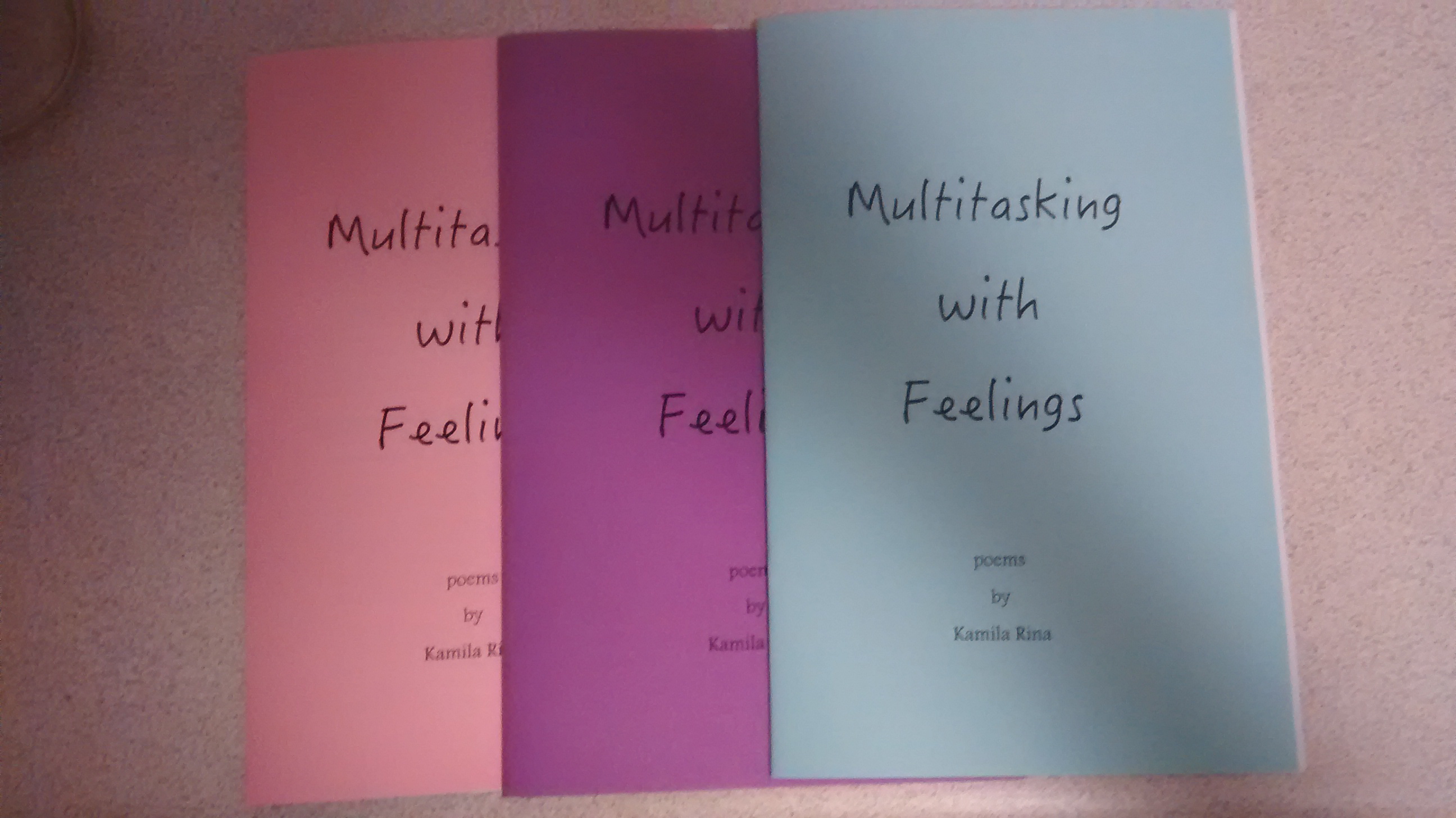 3 poetry chapbooks in pink, purple, and blue. All are titled "Multitasking with Feelings".